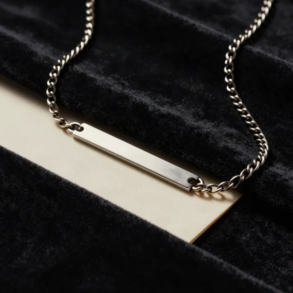 Gold-plated nameplate chain on black velvet with an ivory card edge, seen in tight macro.